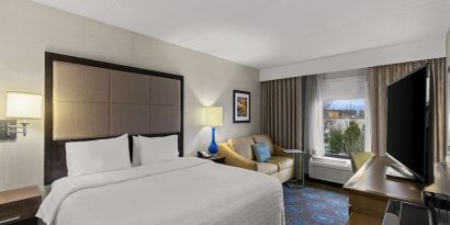 Comfortable king room with sofa and work desk at Hampton Inn Bloomington.