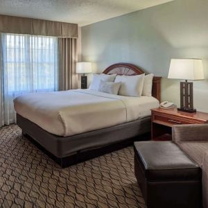 King bed with work desk and lounge seating at Sonesta Atlanta Airport South.