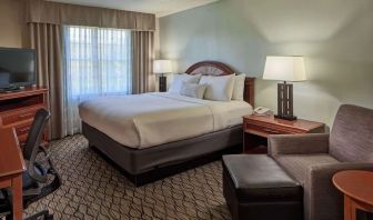 King bed with work desk and lounge seating at Sonesta Atlanta Airport South.