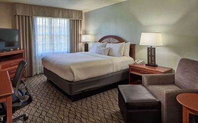 King bed with work desk and lounge seating at Sonesta Atlanta Airport South.