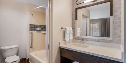 Private guest bathroom with combined shower and tub at Sonesta ES Suites Denver South - Park Meadows.