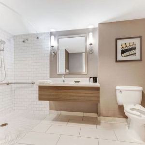 Private guest bathroom with shower and free toiletries at Sonesta Anaheim Resort Area.