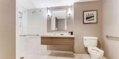 Private guest bathroom with shower and free toiletries at Sonesta Anaheim Resort Area.