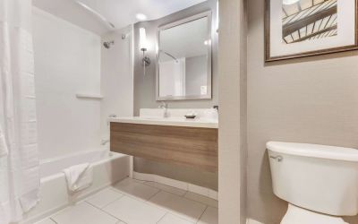 Private guest bathroom with combined shower and tub at Sonesta Anaheim Resort Area.
