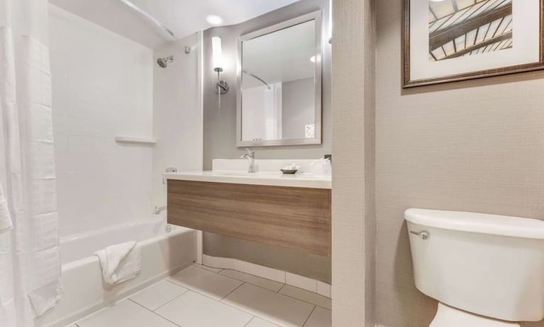 Private guest bathroom with combined shower and tub at Sonesta Anaheim Resort Area.
