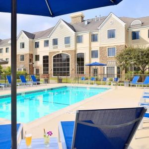 Outdoor pool with lounge chairs at Sonesta ES Suites Charlotte Arrowood.