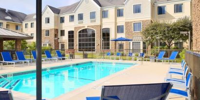 Outdoor pool with lounge chairs at Sonesta ES Suites Charlotte Arrowood.