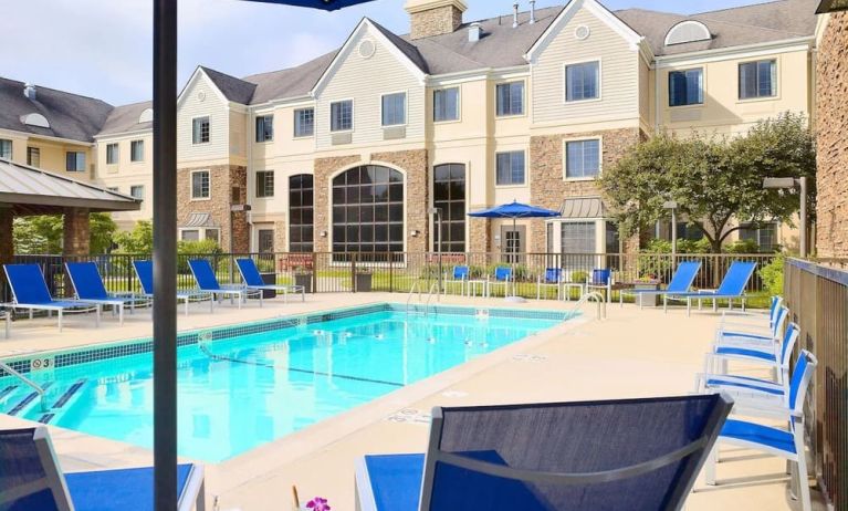 Outdoor pool with lounge chairs at Sonesta ES Suites Charlotte Arrowood.