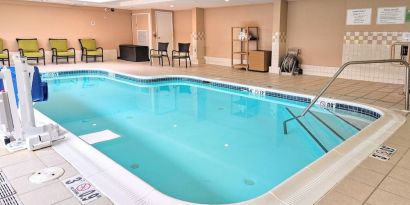 Relaxing indoor heated pool with lounge chairs at Holiday Inn Belcamp - Aberdeen Area.