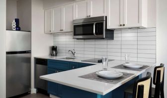 In-room kitchen, equipped with microwave, fridge, sink and breakfast bar at Sonesta ES Suites Chicago Downtown Magnificent Mile - Medical.