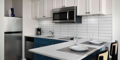 In-room kitchen, equipped with microwave, fridge, sink and breakfast bar at Sonesta ES Suites Chicago Downtown Magnificent Mile - Medical.