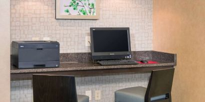 Business center with computer, printer and comfortable chairs at Sonesta ES Suites Charlottesville University.