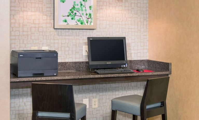 Business center with computer, printer and comfortable chairs at Sonesta ES Suites Charlottesville University.
