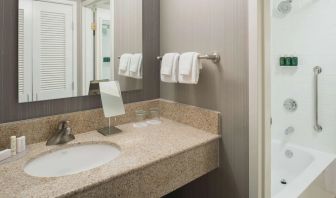 Private guest bathroom with combined shower/tub and free toiletries at Sonesta Select Seattle Bellevue Redmond.