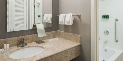 Private guest bathroom with combined shower/tub and free toiletries at Sonesta Select Seattle Bellevue Redmond.