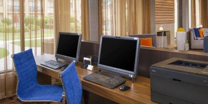 Business center with computers, printer and ergonomic chairs at Sonesta Select Charlotte University Research Park.