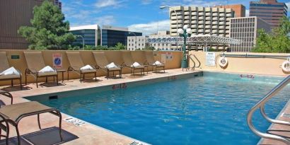Refreshing outdoor pool surrounded by sunbeds at DoubleTree By Hilton Albuquerque.