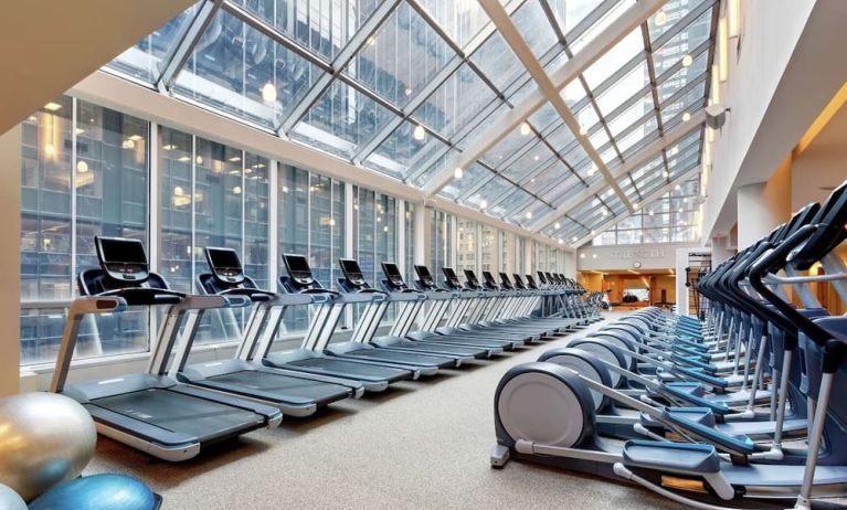 Well-equipped fitness center with natural light at New York Hilton Midtown.