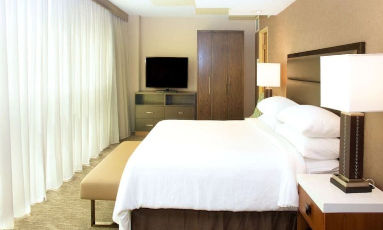 Comfortable king room with TV and natural light at Embassy Suites By Hilton Seattle-North-Lynnwood.