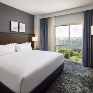 Comfortable king size bed with natural light at Hilton Charlotte Airport.
