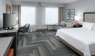 Spacious king bed room with work desk and sofa at Hampton Inn & Suites By Hilton Atlanta Perimeter Dunwoody.
