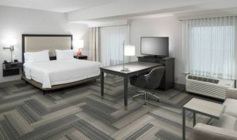 King bed with work desk and living area at Hampton Inn & Suites By Hilton Atlanta Perimeter Dunwoody.