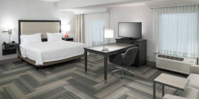 King bed with work desk and living area at Hampton Inn & Suites By Hilton Atlanta Perimeter Dunwoody.