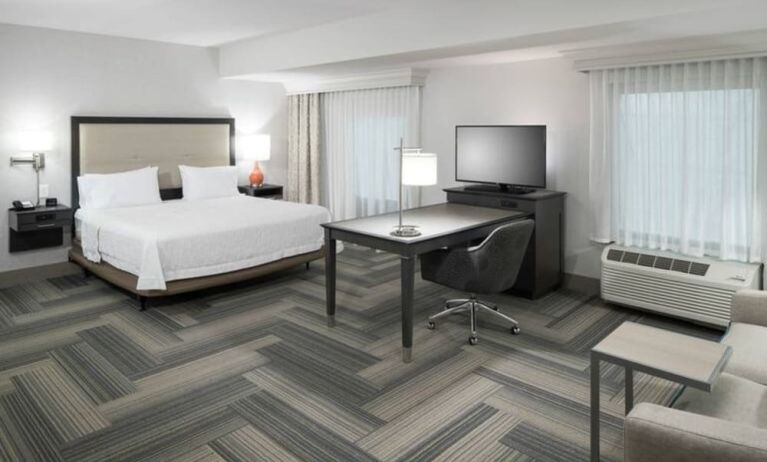 King bed with work desk and living area at Hampton Inn & Suites By Hilton Atlanta Perimeter Dunwoody.