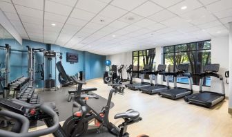 Well-equipped fitness center with a view of the pool at Doubletree By Hilton Houston Medical Center Hotel & Suites.