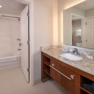 Private guest bathroom with combined shower and tub at Sonesta ES Suites Baltimore BWI Airport.