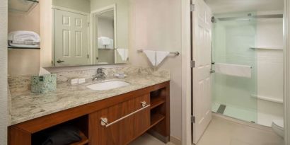 Private guest bathroom with shower and free toiletries at Sonesta ES Suites Baltimore BWI Airport.