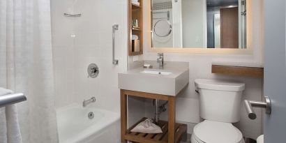 Private guest bathroom with combined shower and tub at New York Hilton Midtown.
