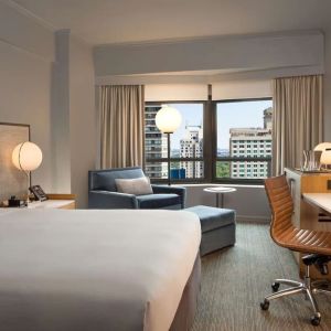 King room with work desk and sofa at New York Hilton Midtown.