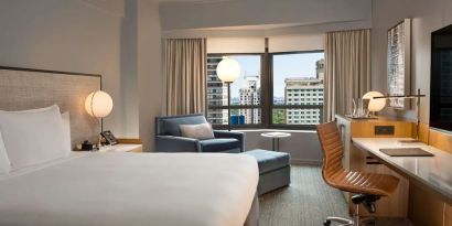 King room with work desk and sofa at New York Hilton Midtown.