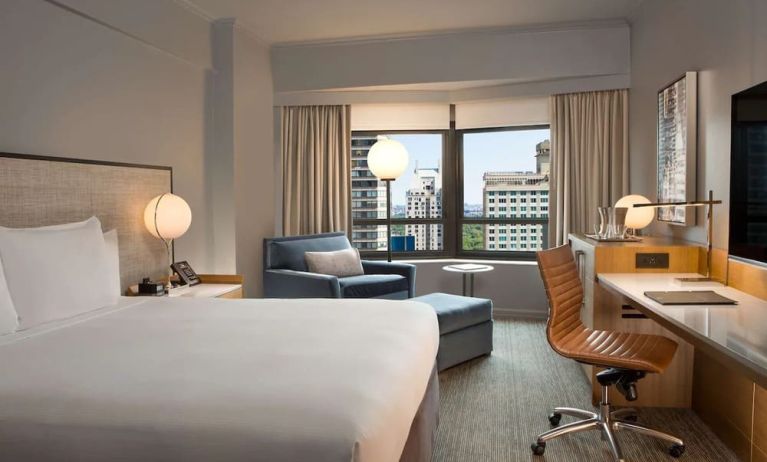 King room with work desk and sofa at New York Hilton Midtown.