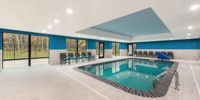 Relaxing indoor heated pool with lounge chairs at Hampton Inn & Suites Benton Harbor.
