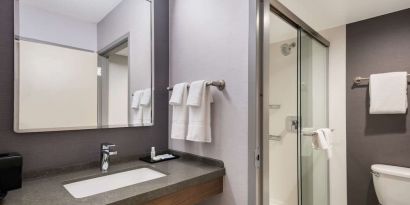 Private guest bathroom with shower and free toiletries at Sonesta Select San Jose Airport.