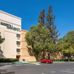 Hotel exterior and parking area at Sonesta Select San Jose Airport.