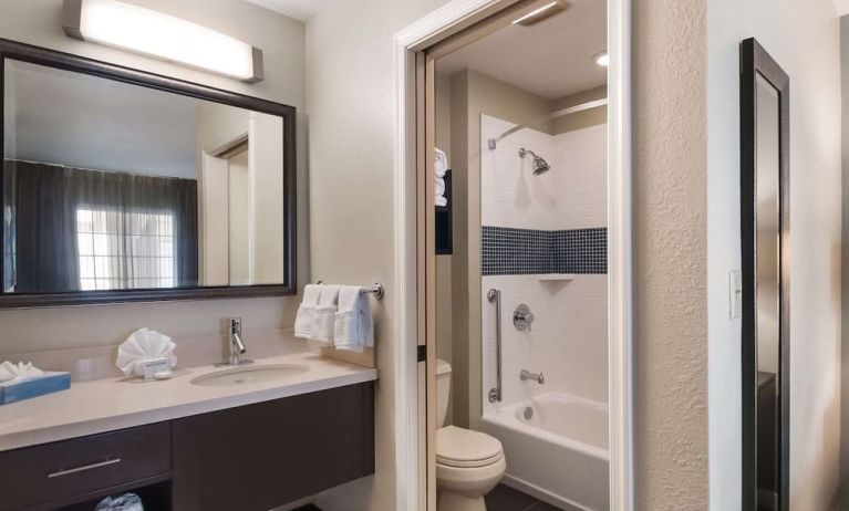 Private guest bathroom with combined shower and tub at Sonesta ES Suites Dulles Airport.