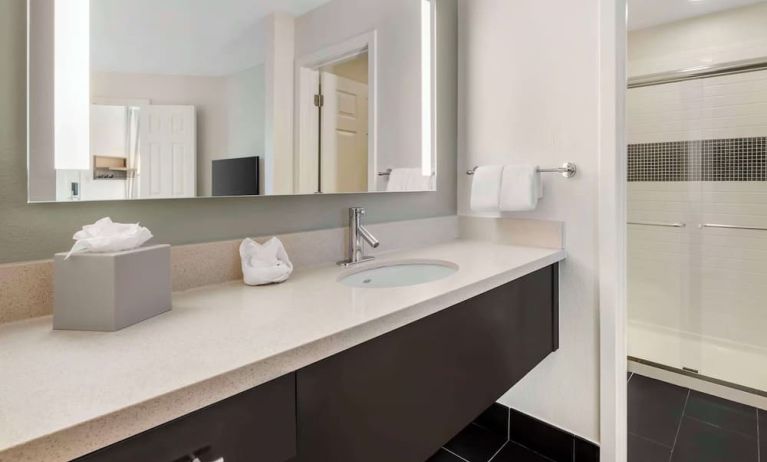 Private guest bathroom with shower and free toiletries at Sonesta ES Suites Dulles Airport.