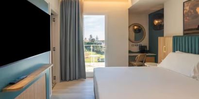 King bed with TV at Terradamari Resort & Spa Marina Di Modica.