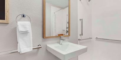 Private guest bathroom with shower and free toiletries at Sonesta Simply Suites Baltimore BWI Airport.