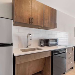 In-room kitchen with fridge, sink and microwave at Sonesta Simply Suites Baltimore BWI Airport. 