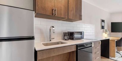 In-room kitchen with fridge, sink and microwave at Sonesta Simply Suites Baltimore BWI Airport. 
