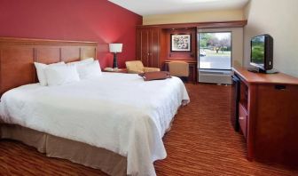 King room with TV screen, work desk and sofa at Hampton Inn Columbus-East.