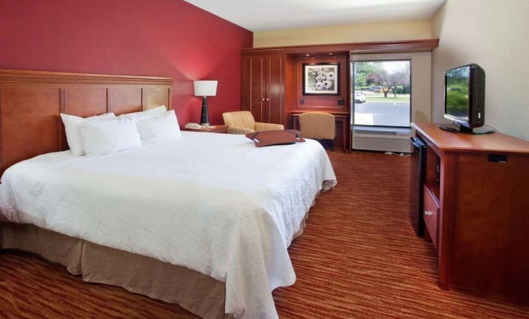 King room with TV screen, work desk and sofa at Hampton Inn Columbus-East.