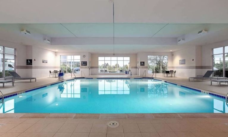Relaxing indoor pool with lounge chairs at Hilton Garden Inn Milwaukee Northwest Conference Center.