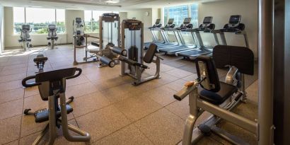 Fitness center with natural light at Hilton Dallas/ Plano Granite Park.