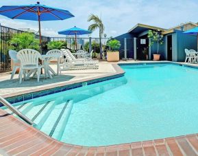 Outdoor pool with lounge chairs at Travelodge LAX By Wyndham.
