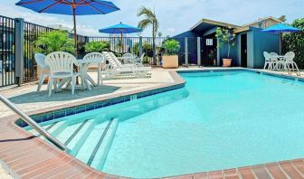 Outdoor pool with lounge chairs at Travelodge LAX By Wyndham.